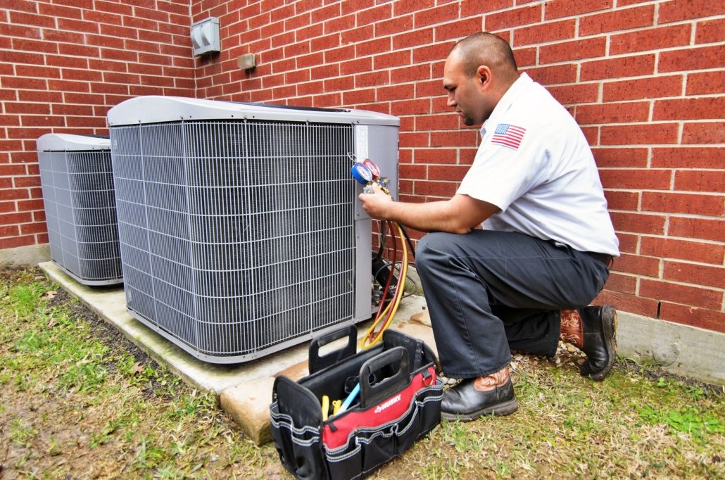 Cooling technician performing a maintenance service on an AC unit 