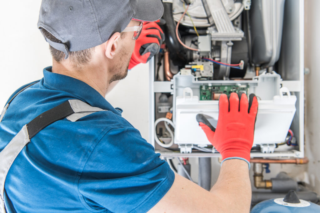 HVAC technician replacing the face of a newly installed residential furnace in Newbury, OH