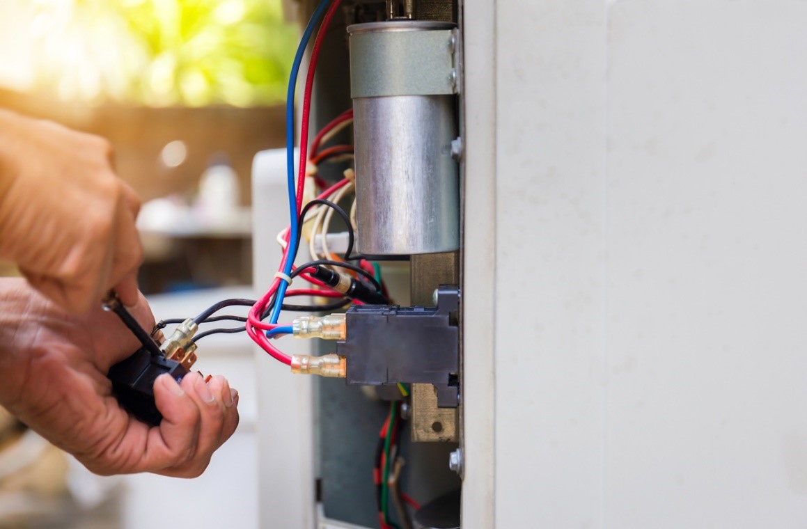 HVAC technician repairing a residential air conditioning unit